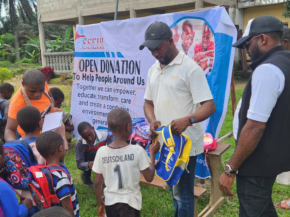 SSEHI volunteers handing out school bags at an open donation drive